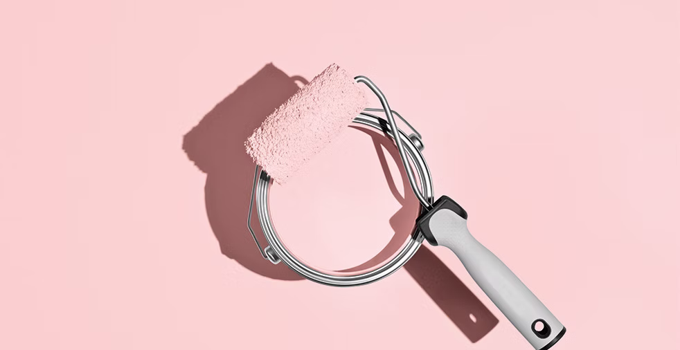 Farbrolle mit rosa Farbe auf rosa Hintergrund